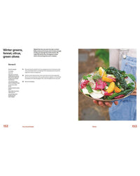 A person in denim overalls holds a vibrant Mediterranean salad from Very Good Salads by Random House, featuring greens, fennel, orange slices, and green olives on the right page; the recipe appears on the left.
