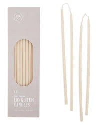 A light gray box labeled Beeswax Long Stem Candles by The Floral Society holds 12 hand-dipped beeswax tapers, shown with two elegant, off-white candles displayed outside and a window revealing the candles inside.