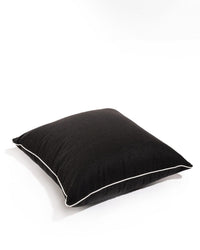 The Euro Throw Pillow - Rivie Black by Business & Pleasure Co features a black square design with white edge piping, displayed on a white surface and background—a stylish, spill-resistant accent for any space.