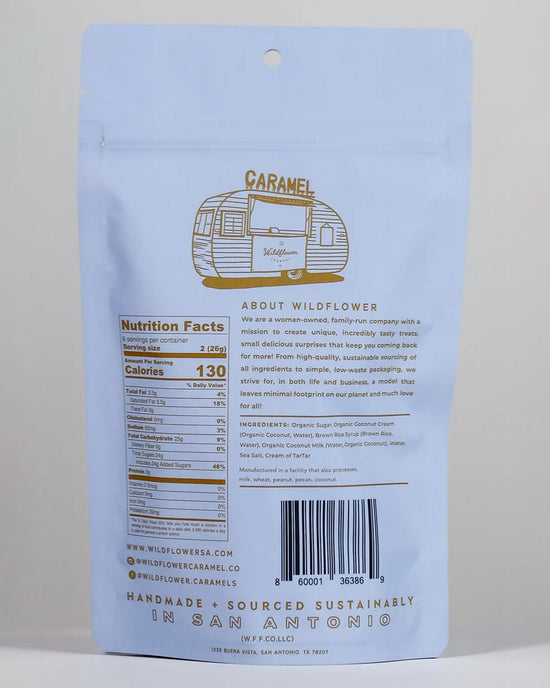 The back of a light blue Wildflower Caramel Co Coconut Caramels (Vegan) in A Bag shows nutrition facts, ingredients, a barcode, the company story, and details on handmade, sustainably sourced production in San Antonio.