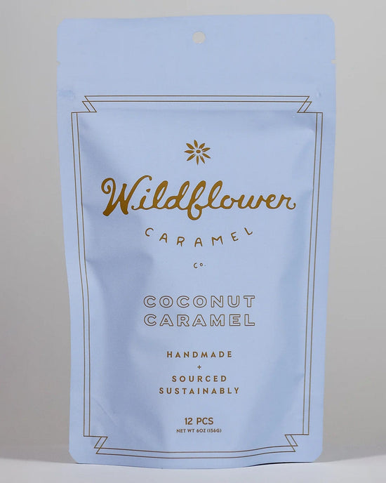 A resealable light blue bag from Wildflower Caramel Co, labeled "Coconut Caramels (Vegan)," contains 12 handmade, sustainably sourced vegan caramels.