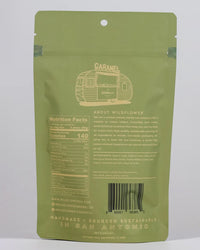 The back of a green Wildflower Caramel Co Dark Chocolate Sea Salt Caramels in A Bag shows nutritional facts, ingredients, company info, barcode, and states the product is handmade and sustainably sourced in San Antonio, TX with fair trade caramels.