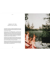 A campfire glows by a calm lake with lush grass and trees, reflecting Nordic nature traditions. The left page reads "Magic of the Nightless Night." From Nordic Magic by Cozy Publishing.