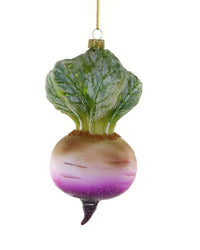 The Cody Foster Heirloom Turnip Ornament is a hand-crafted Christmas decoration shaped like a turnip, featuring green leaves, a white and purple root, and a gold hanging loop.