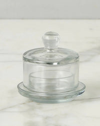 The etúHOME Bistro Glass Jam Jar, Round, features a clear glass design with a knob handle lid, reminiscent of vintage style, and is shown on a white marble surface.