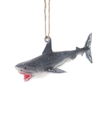 The Cody Foster Shark Ornament is a hand-crafted glass decoration shaped like a shark with glitter, open mouth, and sharp teeth, hanging from a brown string.