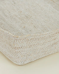 Close-up of the Essential Woven Storage - Letter Tray by Hawkins New York, a rectangular handwoven seagrass basket with textured surface and raised edges. Ideal as a desk organizer, shown against a neutral light background.