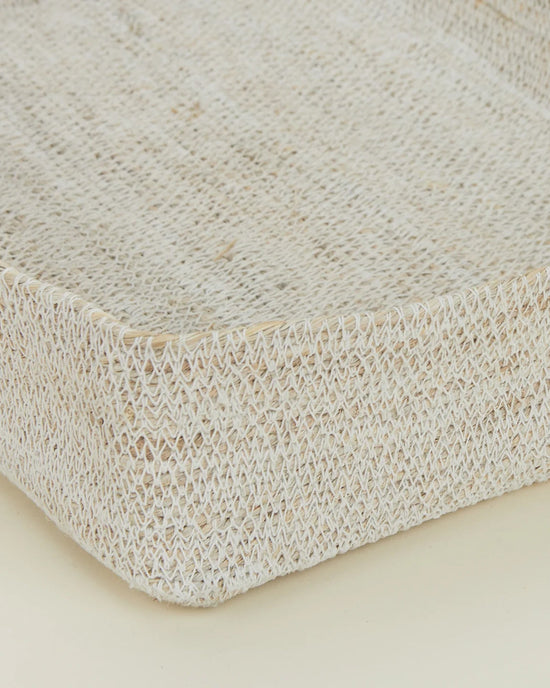 Close-up of the Essential Woven Storage - Letter Tray by Hawkins New York, a rectangular handwoven seagrass basket with textured surface and raised edges. Ideal as a desk organizer, shown against a neutral light background.