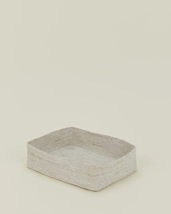 The Essential Woven Storage - Letter Tray by Hawkins New York, a rectangular shallow seagrass basket with soft, rounded edges and minimalist design, sits on a plain light background—ideal as a stylish desk organizer.
