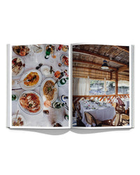 In Italian Summer by Simon & Schuster, an open book reveals two pages: one with an overhead spread of Italian cuisine and drinks; the other showing a rustic, coastal patio restaurant with set tables and chairs.