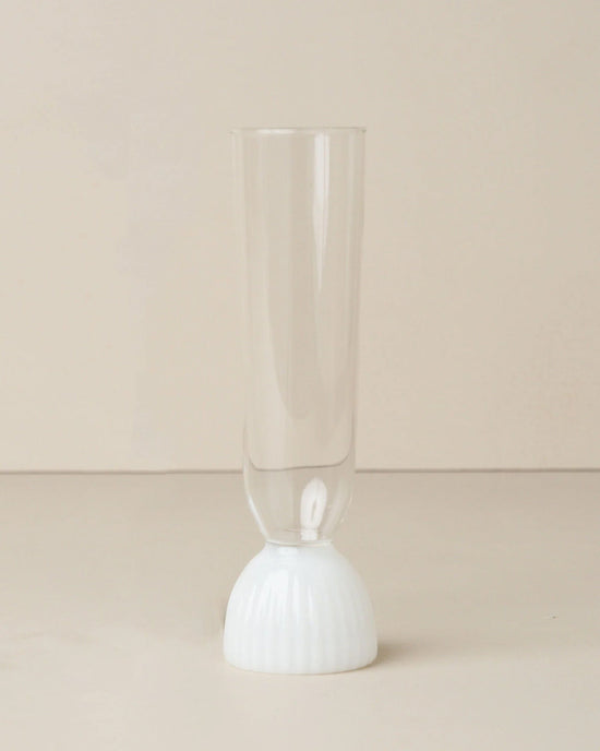 The Kairos Champagne Flute in Opaque White by Saarde features a sleek design, shown on a neutral surface with a beige background.