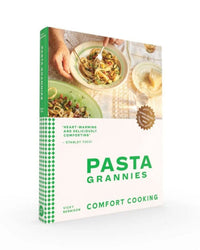 Front cover of Pasta Grannies: Comfort Cookbook by Chronicle Books, showing people enjoying authentic Italian food at a table, with a green and white design and a quote from Stanley Tucci.