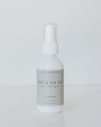 A white Near & Native Room & Body Mist in Sage + Sea Salt stands against a plain background. The Maine-made label notes its 2 oz size and features a fresh, calming blend of woody sage and sea salt scents.