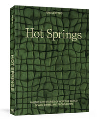 Hot Springs by Random House is a green hardback book with a textured, water-like cover, featuring photos and stories about how people soak, swim, and relax in natural hot springs worldwide.