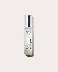 A clear glass bottle of Rosie Jane Perfume Oil in Remi with a silver cap and minimalist black text, set against an off-white background, embodies a fresh California citrus scent.