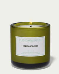 The Green Goddess Candle by Flamingo Estate glows in a green glass jar, labeled as an 8 oz hand-poured vegetable wax candle from Los Angeles.