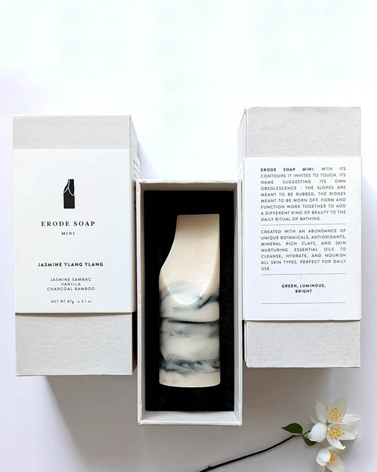 A marble-patterned bar of handmade soap by Ume Studio, the Erode Soap Mini in Jasmine Ylang Ylang, comes boxed with product details and a description printed on the inside flaps.