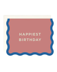 The Amy Heitman "Happiest Birthday - Wave Edge" single card features a pink front, blue wavy border, white “HAPPIEST BIRTHDAY” text, a blank interior, and comes with an off-white envelope.