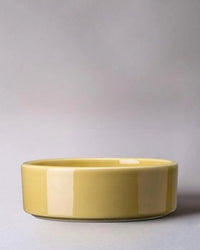 The Hoff Glazed 7.1 inch Saucer in Pale Yellow from Bergs Potter is a round, shallow ceramic piece with a glazed terra cotta finish, shown on a plain surface against a neutral background.