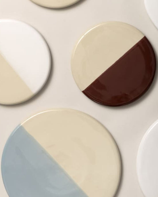 The Nuna Glazed 11 inch Tray in Sandstone/Misty Blue by Bergs Potter features a round stoneware design with diagonal color splits—ideal for elevating your home décor.