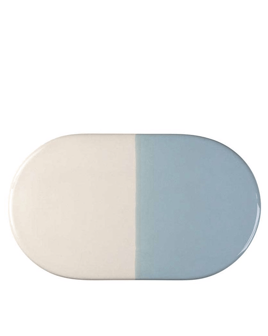 The Bergs Potter Nuna Glazed 13.4 x 7.9 Tray in Sandstone/Misty Blue is a durable, food-safe stoneware plate with a color block design—half cream, half light blue—adding lasting style to your table.