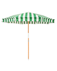 The Amalfi Umbrella - Crew Canyon Green Stripe by Business & Pleasure Co features a UV-resistant green and white striped canopy and a wooden pole, shown fully open against a white background.