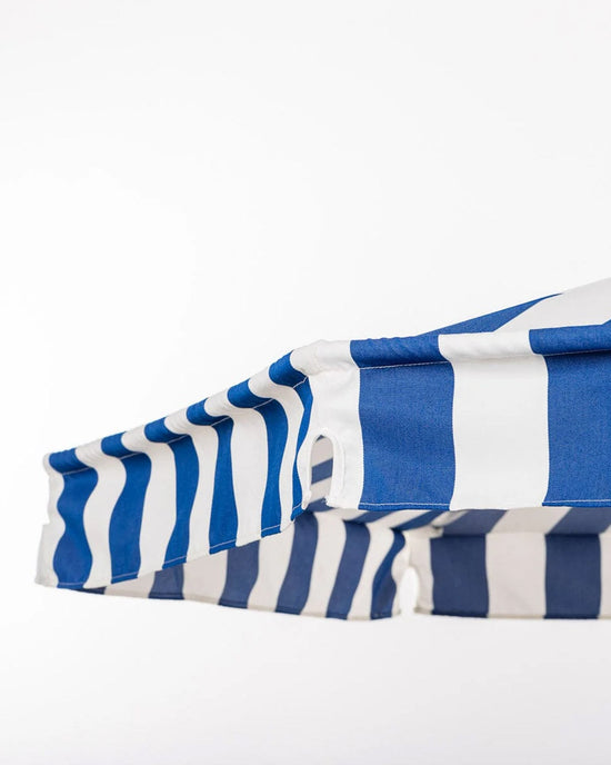 A close-up of the Amalfi Umbrella – Crew Mediterranean Blue Stripe by Business & Pleasure Co, featuring blue and white stripes against a plain white background.