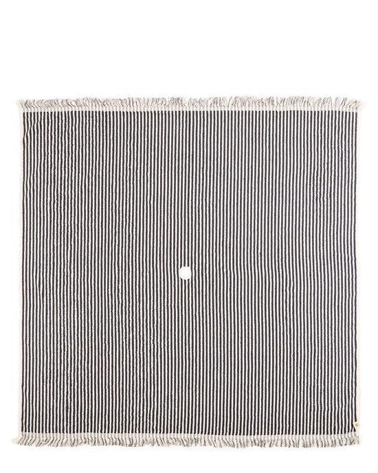 The Beach Blanket - Laurens Navy Stripe by Business & Pleasure Co is a rectangular 100% cotton blanket with black and white stripes, fringe edges, and a small round hole in the center.