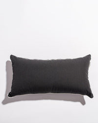 A Rectangle Throw Pillow in Rivie Black by Business & Pleasure Co sits on a white surface, casting a faint shadow left. Made with Pleasuretex® fabric, it exemplifies the premium quality of outdoor pillows.
