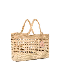 The caminito Canasta Chica Bag in Natural is a woven beige market tote with two handles and a small leather tag, shown against a white background.