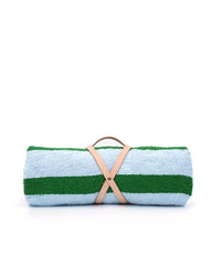 The caminito Marea Vuelta - Blanket Roll features light blue and green stripes, secured with a tan leather strap, shown against a white background—ideal for indoor or outdoor use.