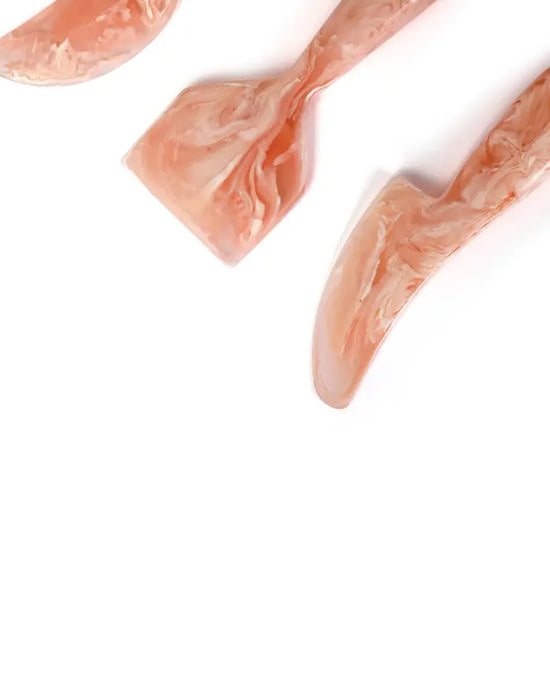 The Casa Amarosa Resin Cheese Knife Set of 3 in Pink, featuring pink marbled resin handles in assorted shapes, is arranged diagonally on a white background.
