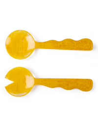 The Casa Amarosa Resin Salad Server Set in Mustard features two marbled yellow utensils—a solid spoon and a forked server—displayed side by side on a white background.