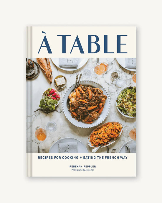 Cover of A Table by Chronicle Books, showing a French meal spread on a white table with plates, drinks, and dishes—perfect inspiration for French cooking at home.