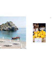 A small boat floats by a rocky island and beach, beside a box of large yellow lemons—perfect for Sicilian desserts or classic recipes youll find in Recipes from Sicily by Chronicle Books.