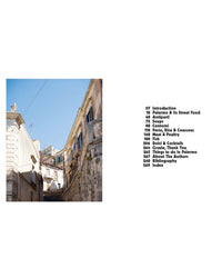 A narrow stone street between old buildings under a clear sky; to the right, a table of contents from Recipes from Sicily by Chronicle Books, showcasing Palermo’s history and iconic Sicilian recipes.