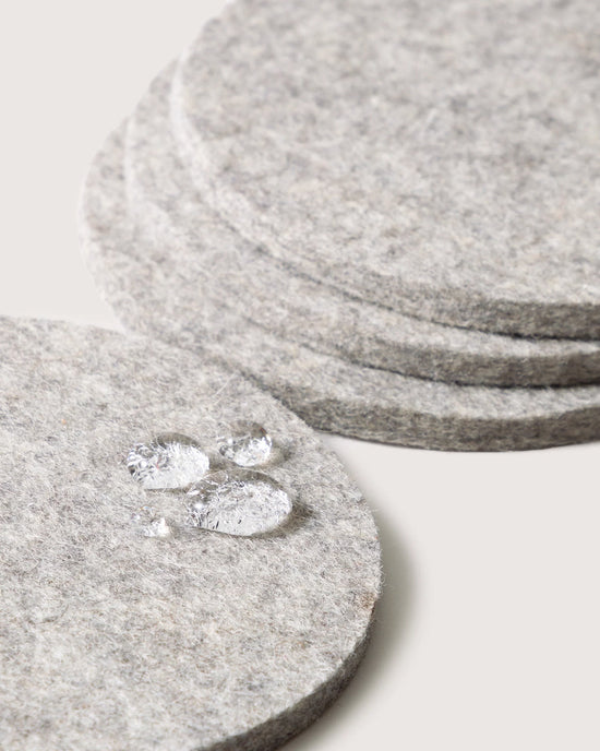 Close-up of graf lantz Bierfilzl Merino Wool Felt Round Coaster Solid in Granite (4 Pack), showing water droplets beading on the German Merino wool surface.