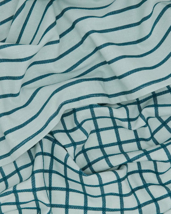 The Essential Dish Towels in Sky/Peacock by Hawkins New York feature light blue cotton with dark teal wavy and grid patterns—stylish, folded, and perfect for your kitchen. Set of 2.