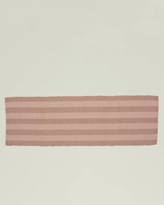 The Essential Floor Runner in Blush by Hawkins New York, featuring pale pink and beige stripes and crafted from recycled fibers, is displayed flat on a light, neutral background.