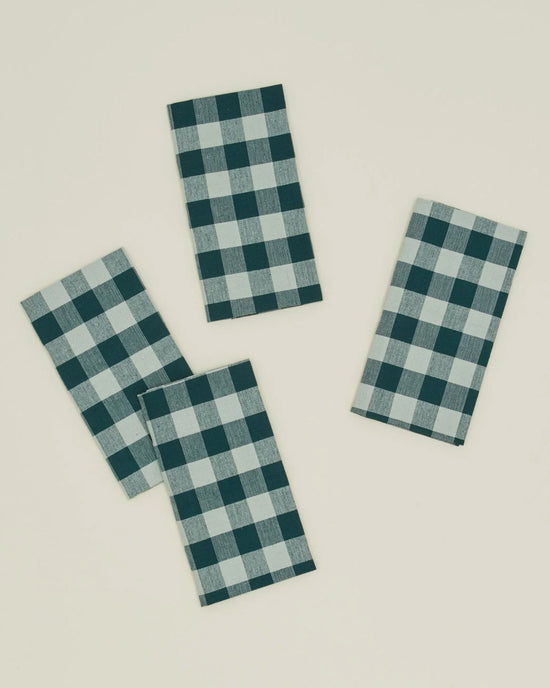 The Essential Gingham Dinner Napkins in Sky/Peacock by Hawkins New York are a set of four 100% cotton napkins, each featuring a blue and white checkered pattern.