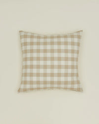 The Hawkins New York Essential Gingham Pillow, 18x18 inches in Ivory/Flax, features a beige and white check pattern in European linen. Machine washable, it combines timeless style and easy care for any space.