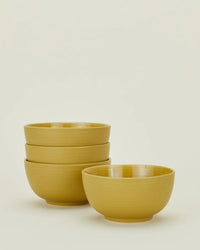 Four Essential Large Bowls in Mustard by Hawkins New York, three stacked and one in front, from their set of 4, are shown against a plain light background.