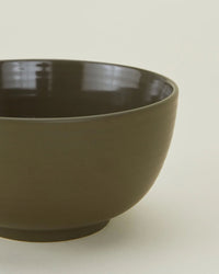 A close-up of the Essential Large Bowls in Olive by Hawkins New York, a set of 4 round, dark green stoneware bowls with a smooth finish—stylish, durable, and dishwasher safe.