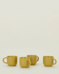 Four mustard Essential Mugs by Hawkins New York are arranged in a row on a plain light background, highlighting this vibrant set of 4.