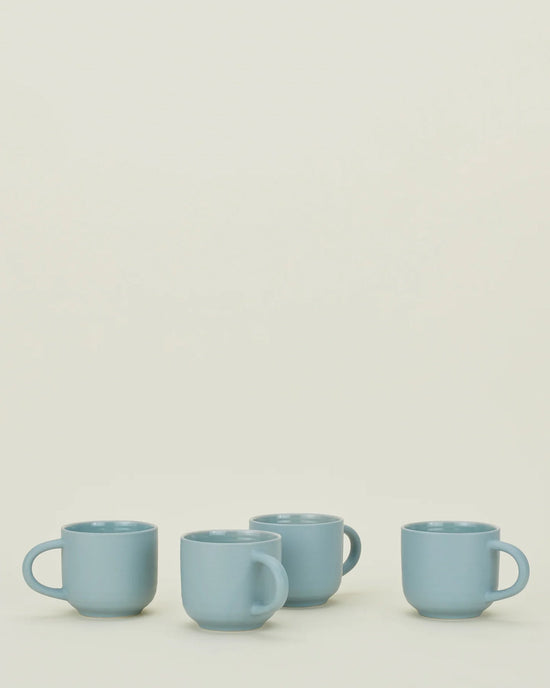 A set of four Hawkins New York Essential Mugs in Sky is arranged in a row on a plain, light surface with a neutral background.
