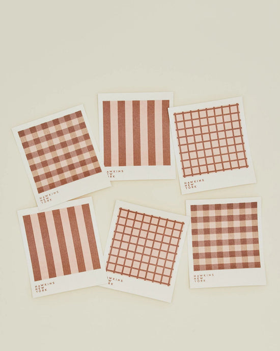 A set of 6 Essential Swedish Dishcloths in Blush/Terracotta by Hawkins New York is arranged on a light surface, featuring red and white checkered or striped patterns inspired by classic Swedish design.