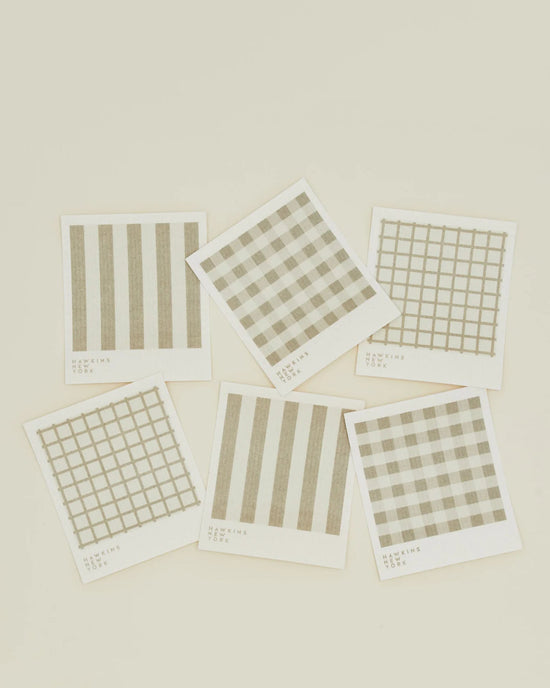 The Hawkins New York Essential Swedish Dishcloths in Ivory/Flax (set of 6) feature assorted beige geometric designs, like stripes and grids, arranged on an off-white background for a modern look.