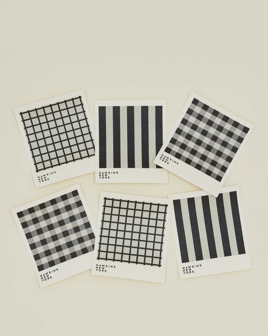 Six Essential Swedish Dishcloths in Light Grey/Black by Hawkins New York feature various black and white patterns. This eco-friendly set of 6 is perfect for stylish kitchen cleaning.