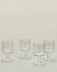A set of 4 Hawkins New York Stemmed Simple Seeded Glassware in Clear is arranged on a light surface with a neutral background.