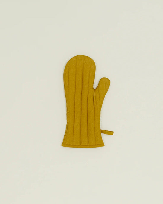 A Simple Linen Oven Mitt in Mustard by Hawkins New York, featuring vertical stitching and heat-resistant padding, lies flat on a plain light background.